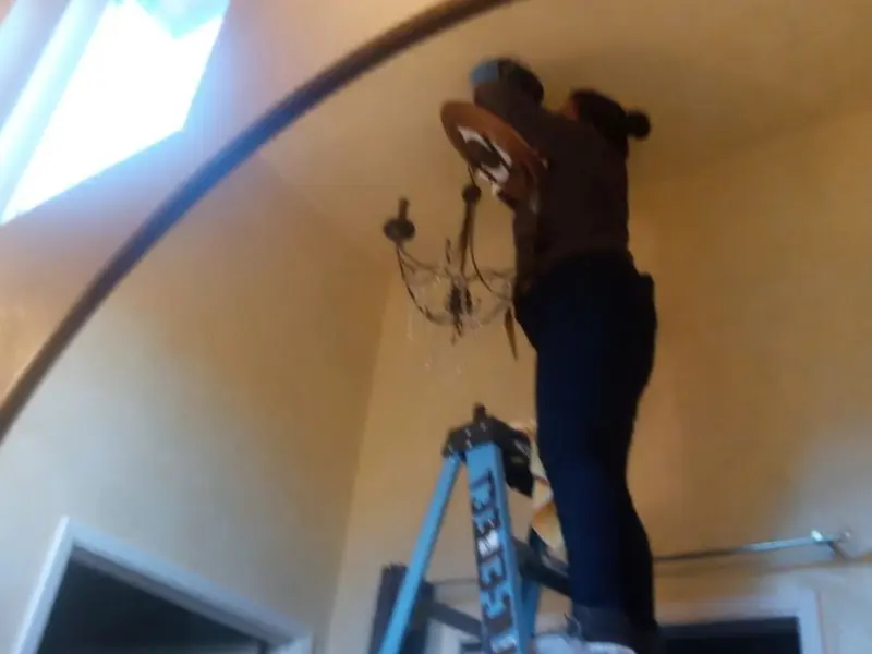 Electrician installing a chandelier in a Battlefield residence